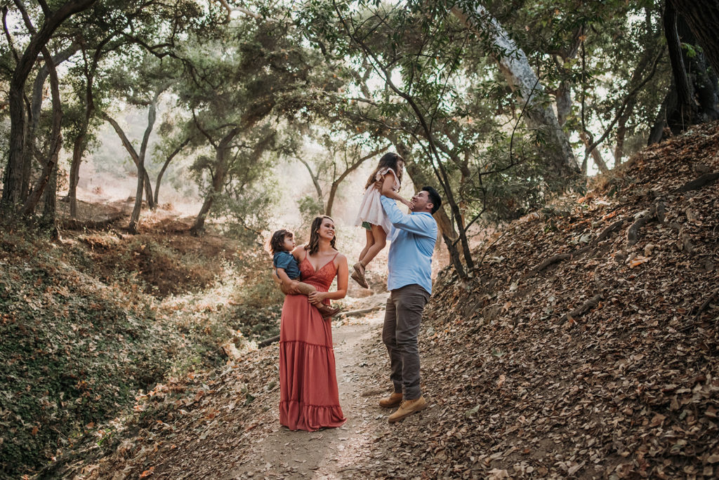 A family of four takes family photos on a trail location in los angeles