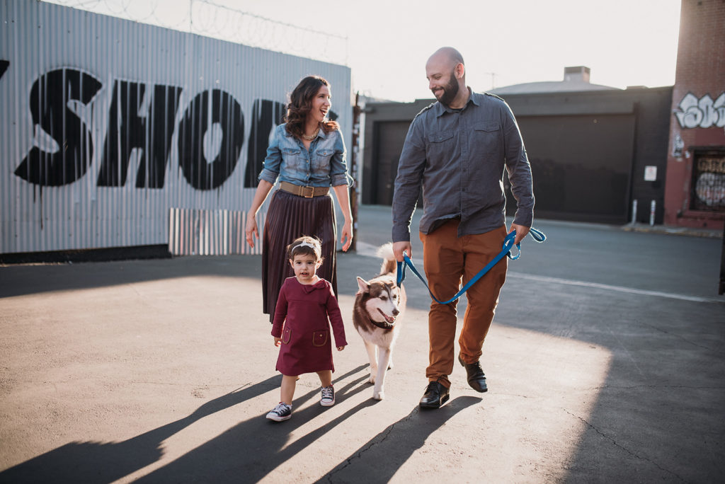 two parents, a toddler and a dog walk in DTLA, one of the family photo locations in los angeles 